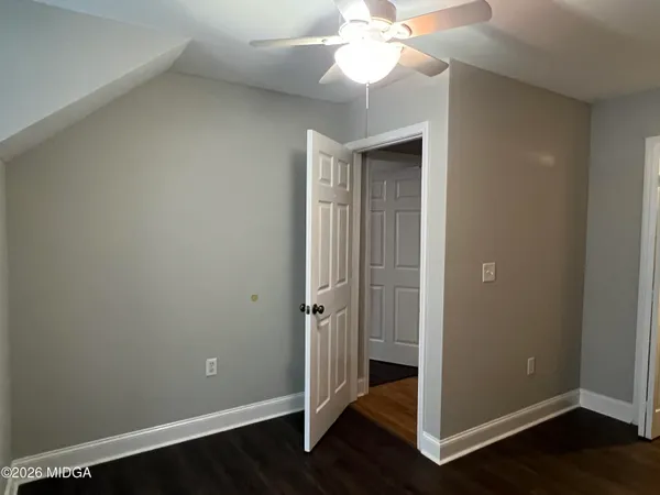 an empty room with wooden floor and door