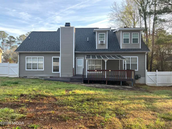 a view of a house with a yard and sitting area