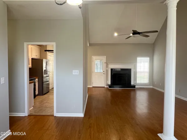 an empty room with wooden floor and fireplace