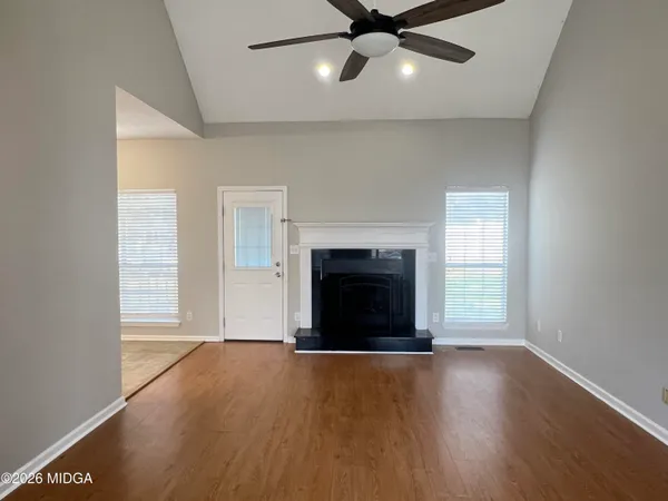 an empty room with windows and fireplace