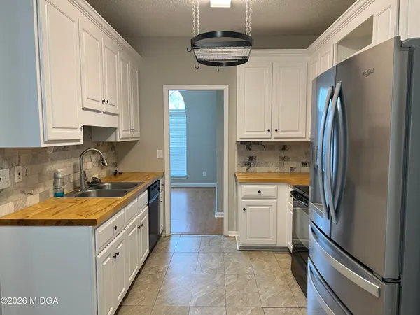 a kitchen with white cabinets and stainless steel appliances