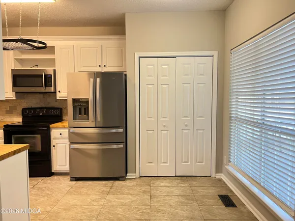 a kitchen with stainless steel appliances granite countertop a refrigerator and a stove top oven