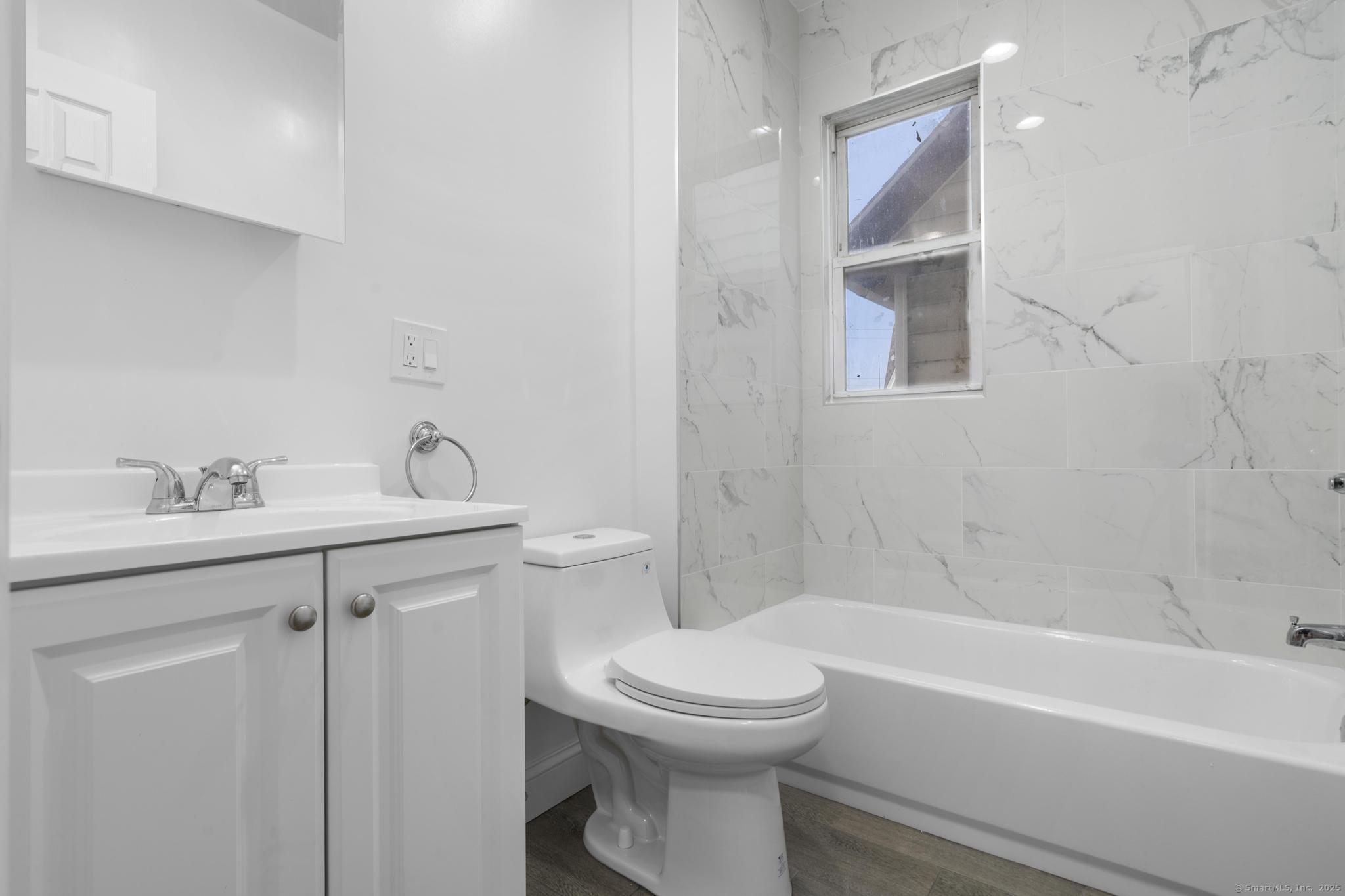 565 Carroll Avenue, Unit 1 Bridgeport, CT 06607 - Photo 11 of 22 a bathroom with a sink toilet and shower