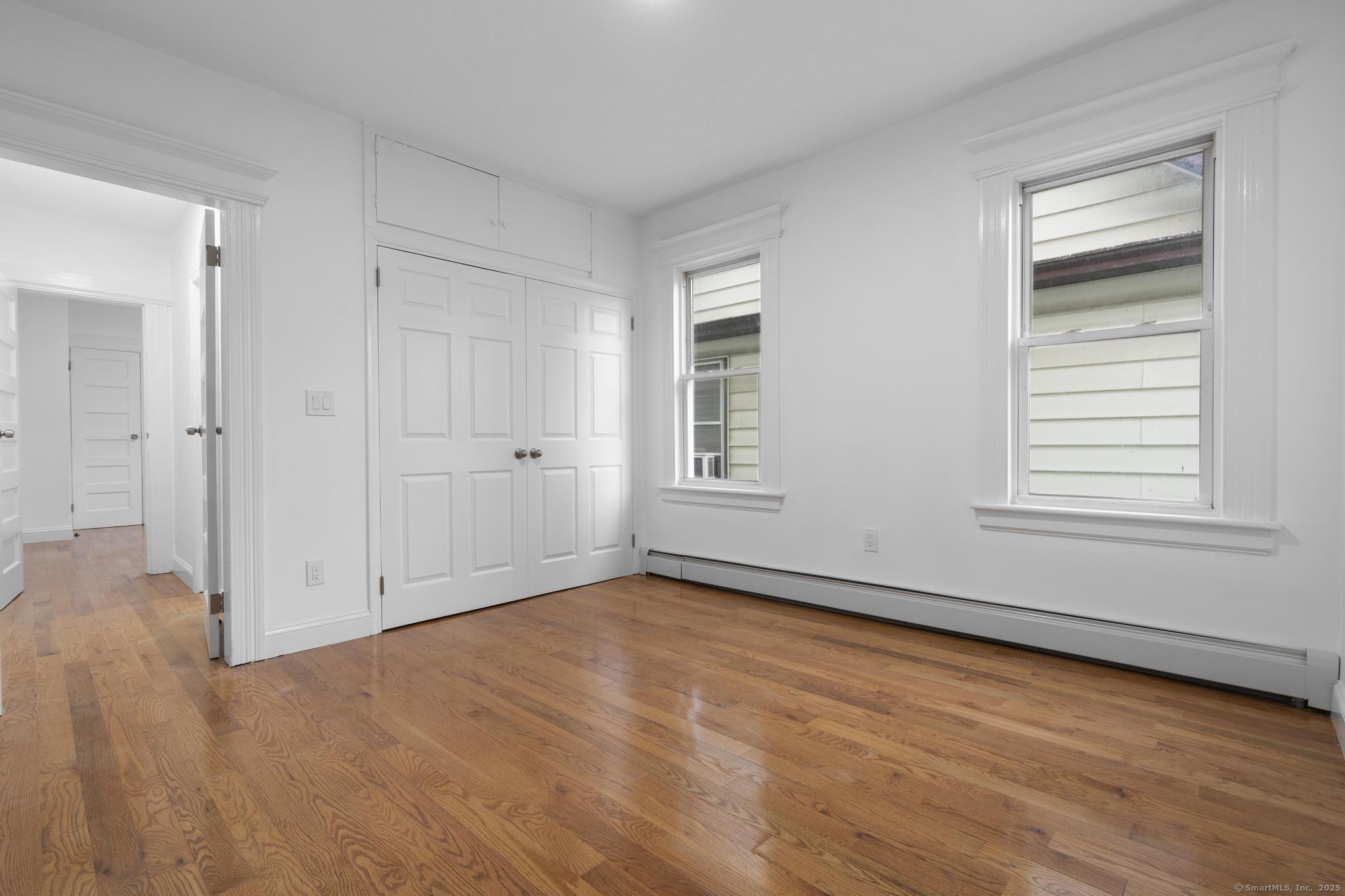 565 Carroll Avenue, Unit 1 Bridgeport, CT 06607 - Photo 13 of 22 a view of an empty room with wooden floor and a window