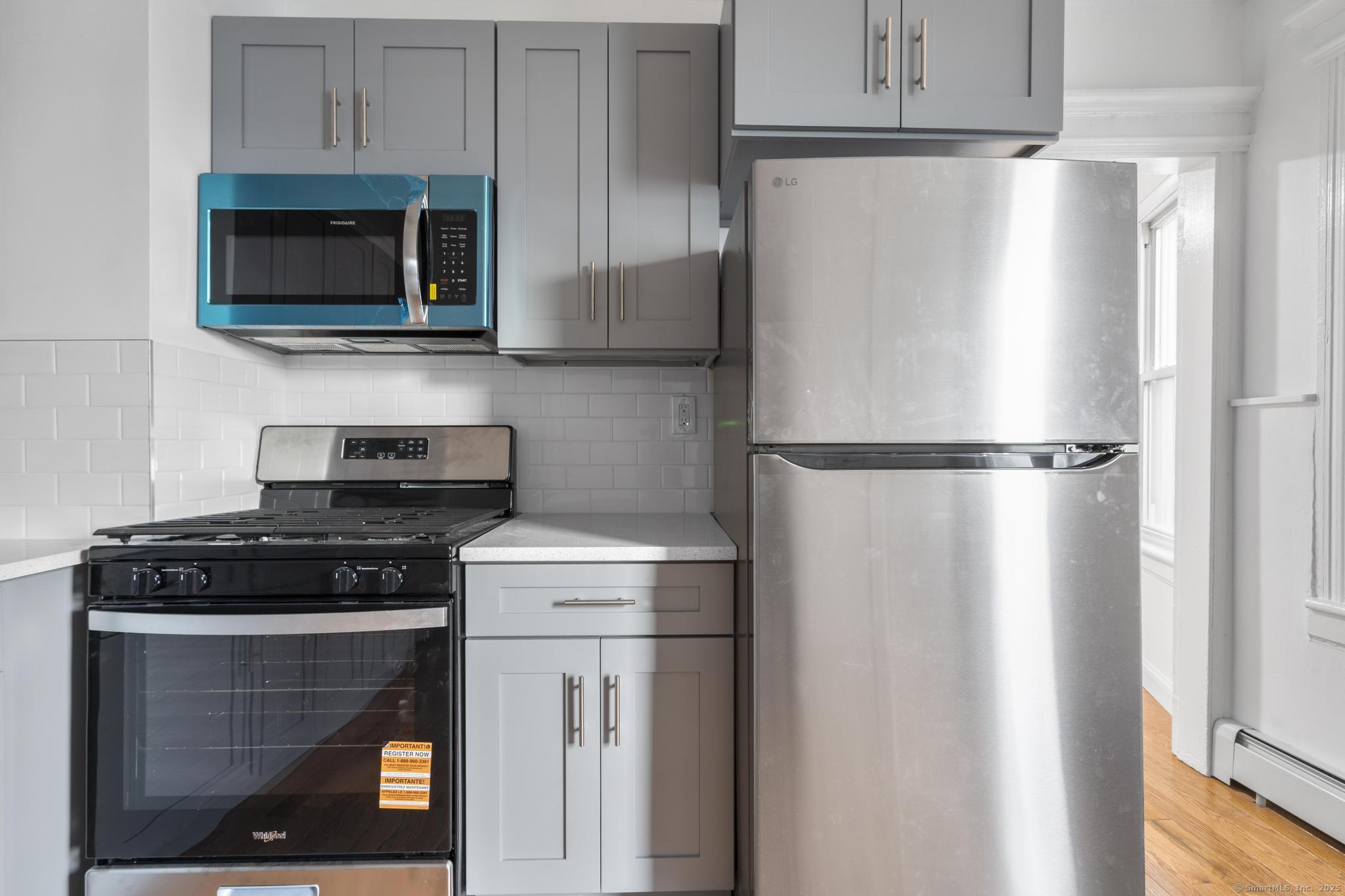 565 Carroll Avenue, Unit 1 Bridgeport, CT 06607 - Photo 22 of 22 a kitchen with a refrigerator and a stove top oven