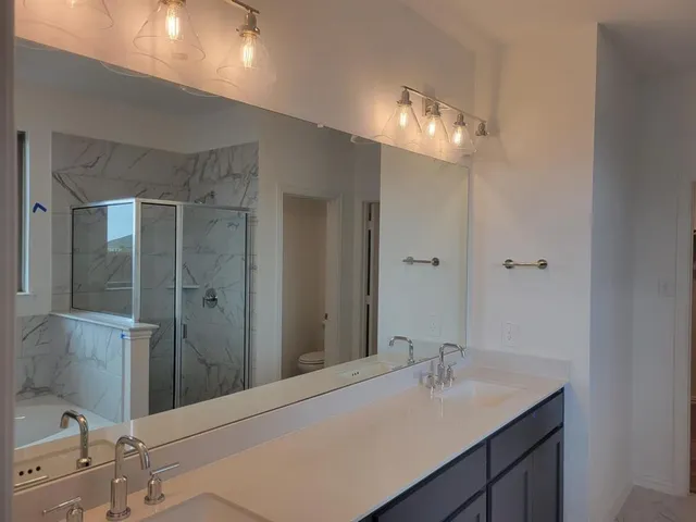 a bathroom with a sink vanity and shower