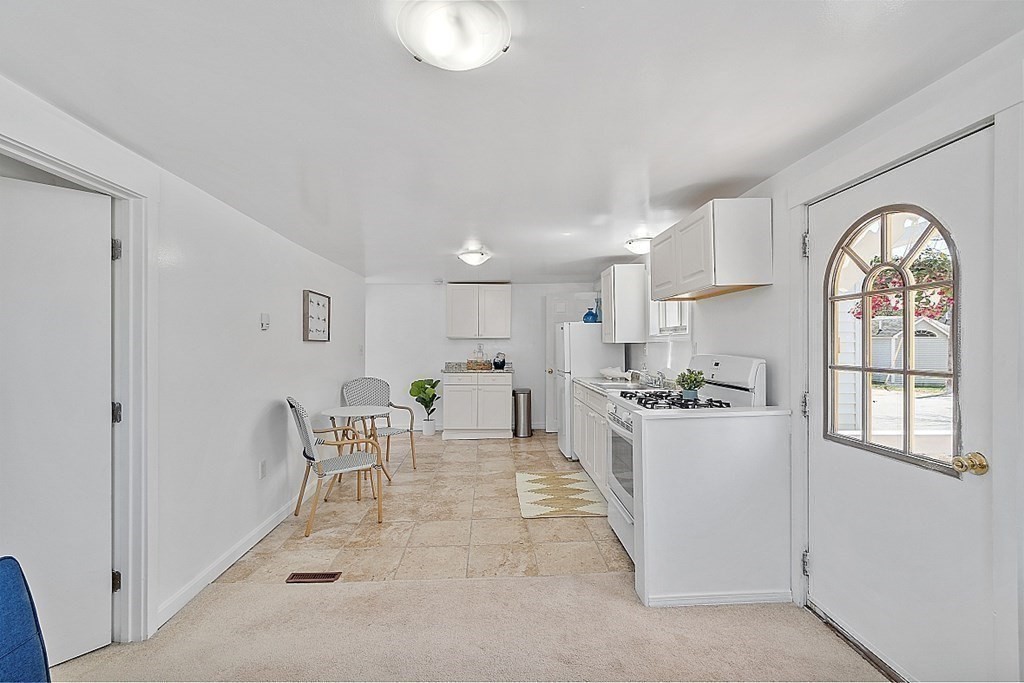 20 Fern Lane Manchester, NH 03109 - Photo 22 of 34 a kitchen with stainless steel appliances a table and chairs