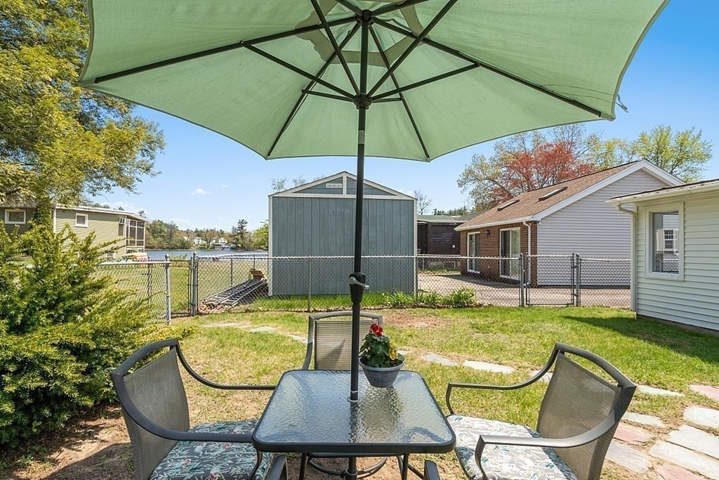 20 Fern Lane Manchester, NH 03109 - Photo 30 of 34 a patio with a table and chairs under an umbrella