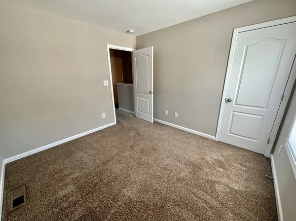 an empty room with closet and mirror