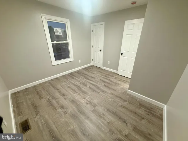 an empty room with windows and closet