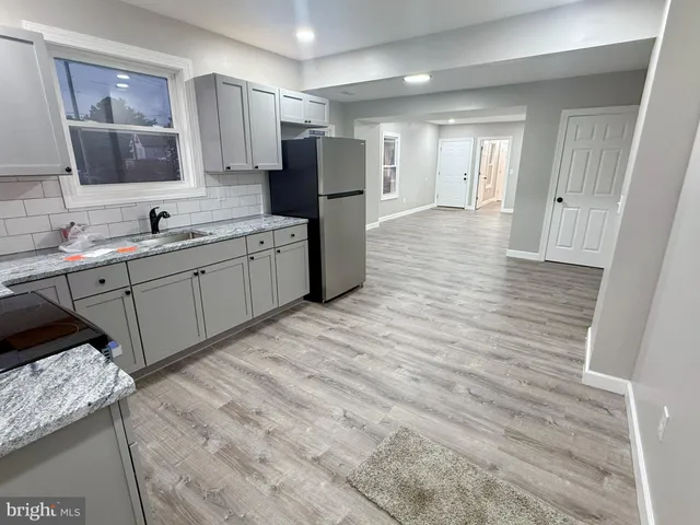 a large kitchen with a sink and refrigerator