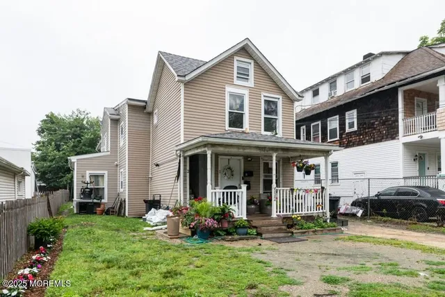 a view of a white house with large windows and a yard