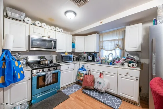 a kitchen with stainless steel appliances granite countertop a stove a sink dishwasher and a microwave oven with cabinets