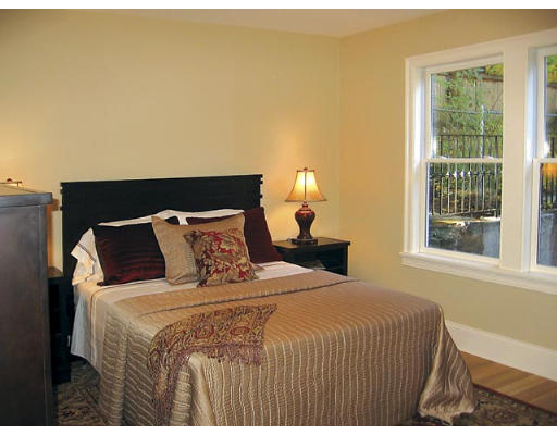 121 University Road, Unit 1 Brookline, MA 02445 - Photo 7 of 13 a bed sitting in a bedroom next to a window
