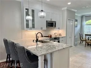 a kitchen with granite countertop kitchen island stainless steel appliances a sink table and chairs