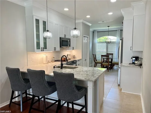 a kitchen with kitchen island granite countertop a sink and a refrigerator