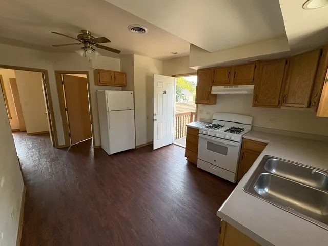 a kitchen with wooden floors and appliances