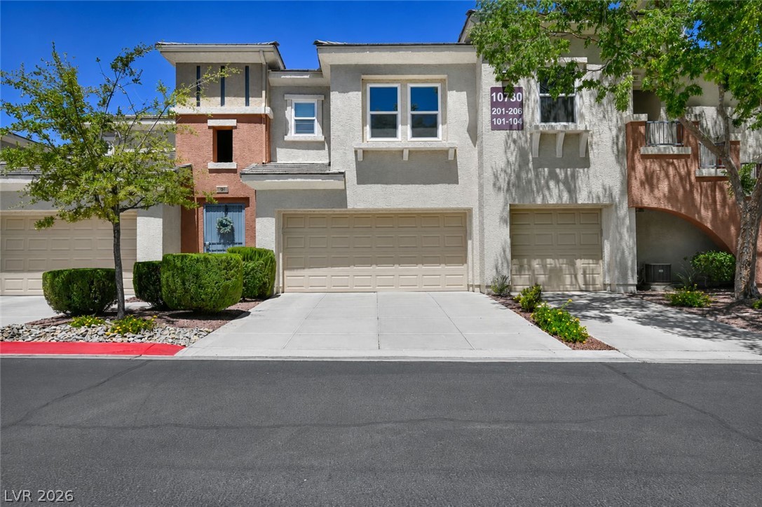 A well-maintained facade features stucco and brick accents with attached garages.