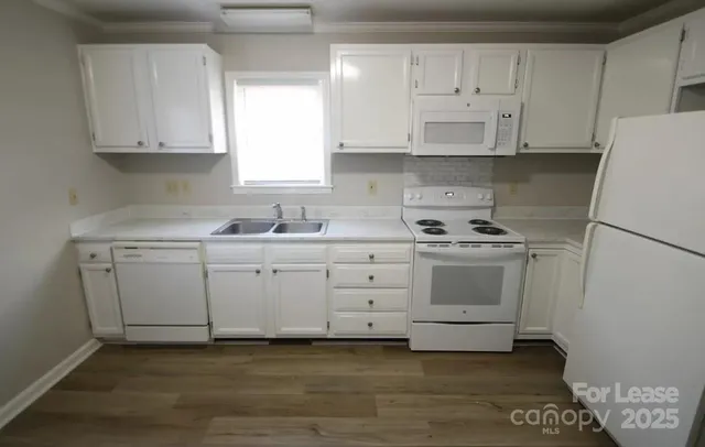 a kitchen with white cabinets and white appliances