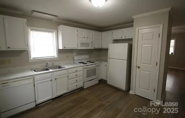 a kitchen with white cabinets and white appliances