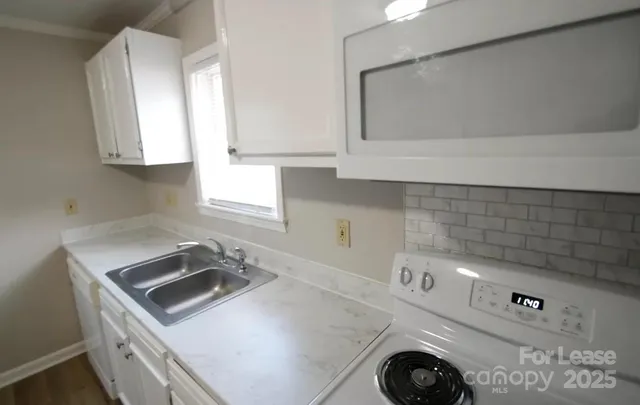 a kitchen with a sink a stove and cabinets