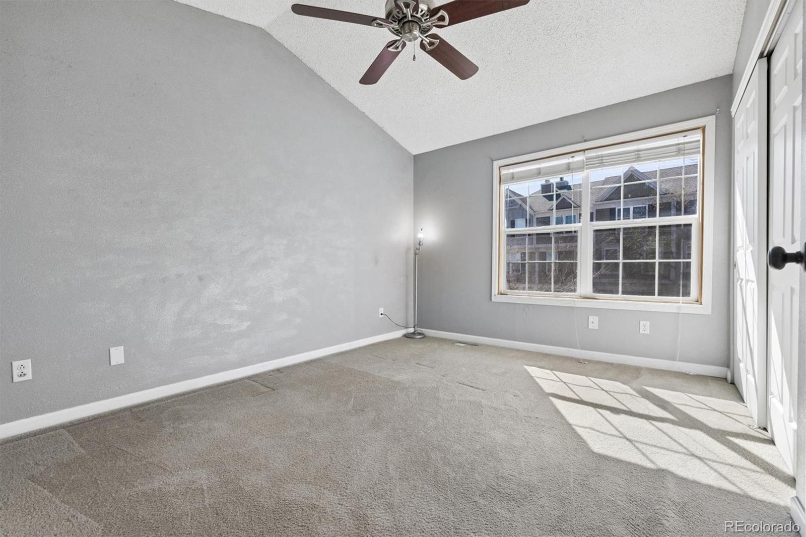 8139 South Fillmore Way Centennial, CO 80122 - Photo 11 of 29 an empty room with a ceiling fan and windows