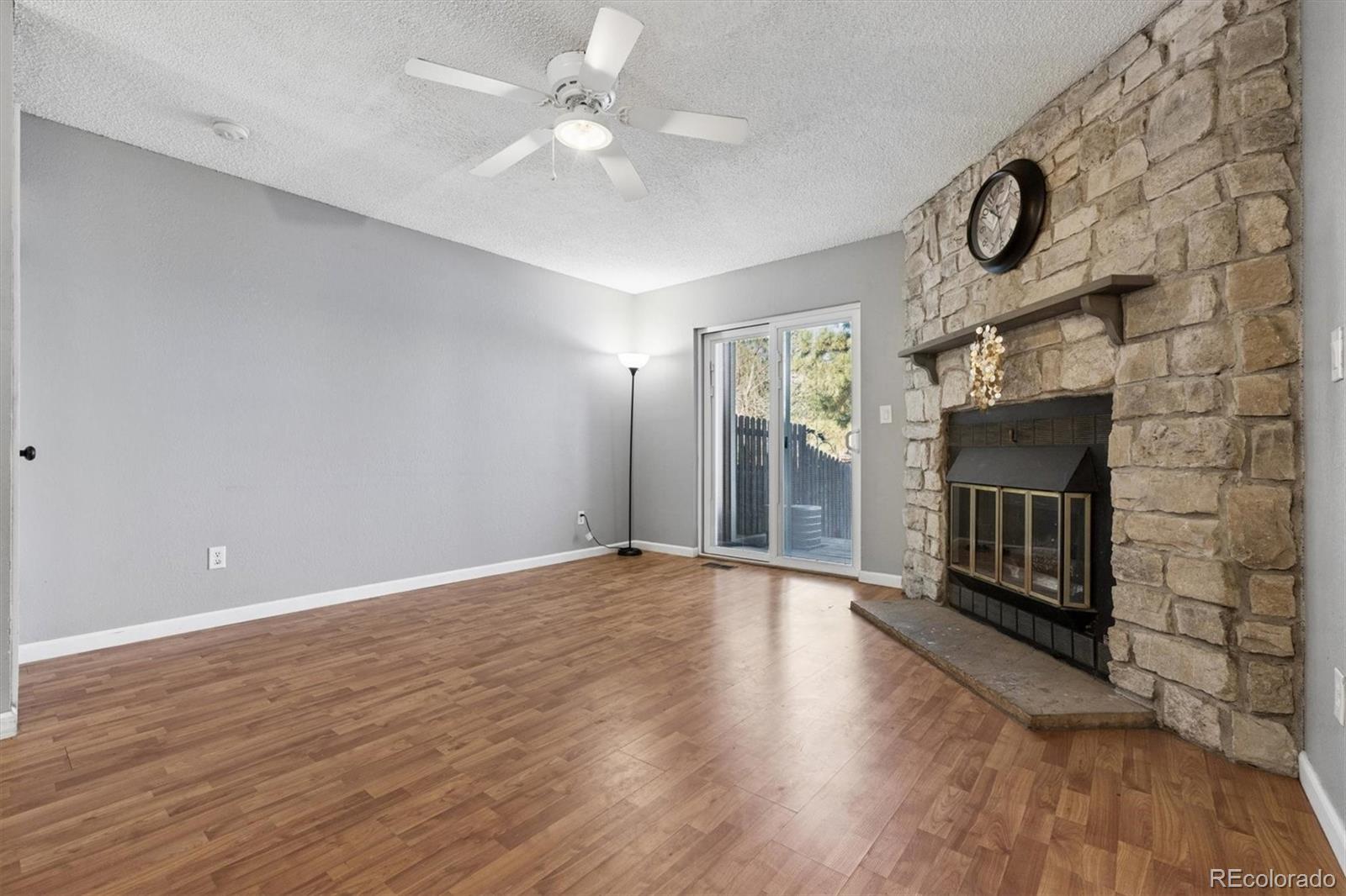 8139 South Fillmore Way Centennial, CO 80122 - Photo 4 of 29 an empty room with wooden floor fireplace and windows