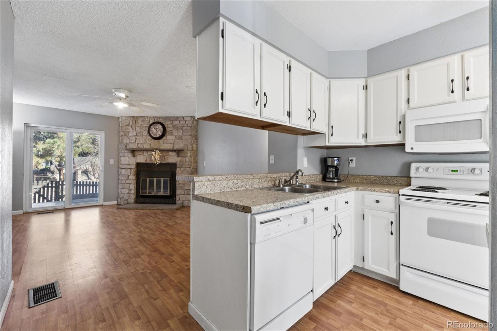 8139 South Fillmore Way Centennial, CO 80122 - Photo 6 of 29 a kitchen with granite countertop a stove top oven sink and cabinets