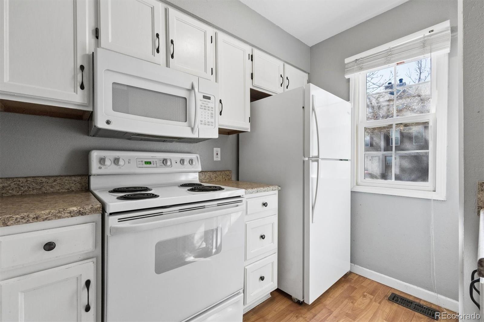 8139 South Fillmore Way Centennial, CO 80122 - Photo 7 of 29 a kitchen with white cabinets and white appliances