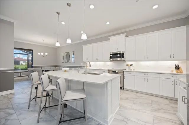 a kitchen with a sink a center island a refrigerator and cabinets
