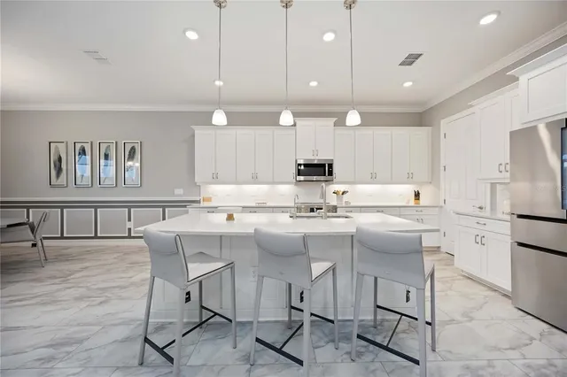 a large white kitchen with a large window and stainless steel appliances