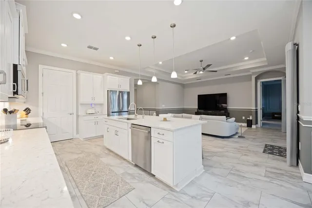 a large white kitchen with a large window and furniture