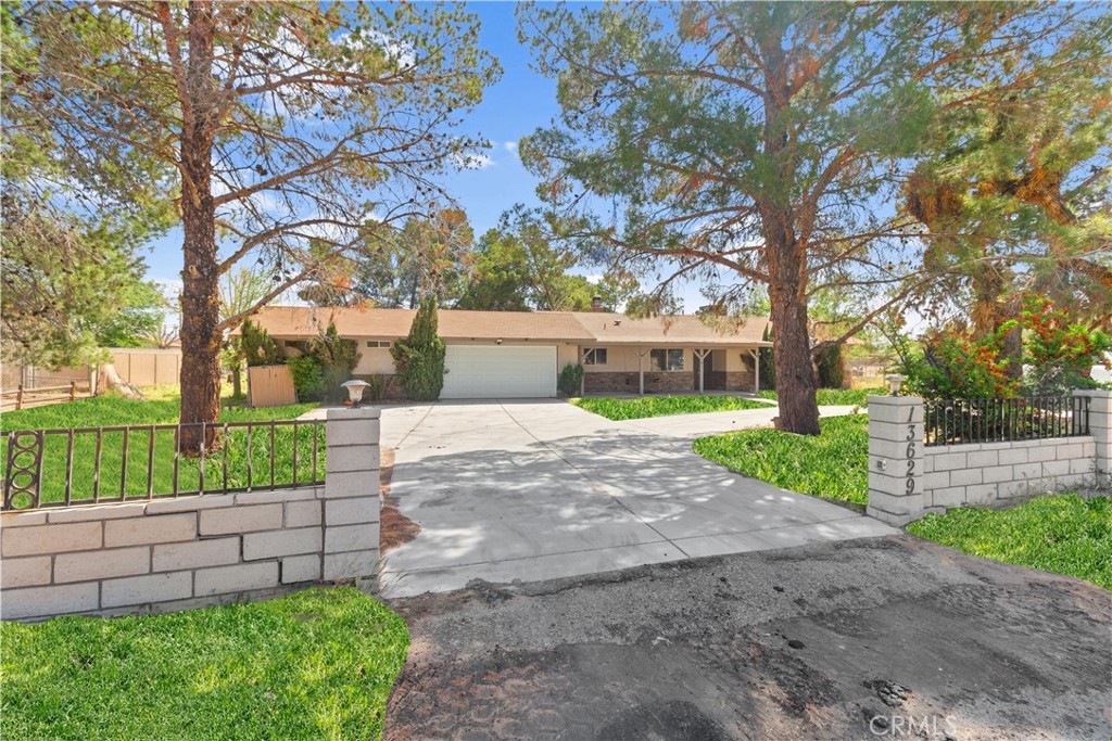 13629 Jicarilla Road Apple Valley, CA 92308 - Photo 1 of 1 a view of a yard with plants and a large tree