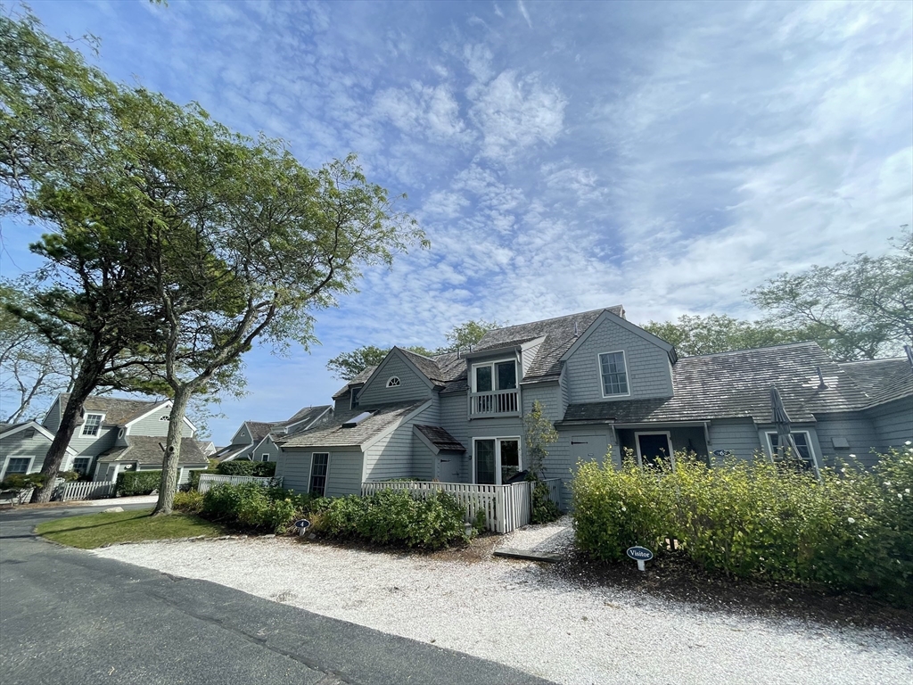 4 Colemans Way, Unit 702 Mashpee, MA 02649 - Photo 2 of 23 a front view of a house with a garden