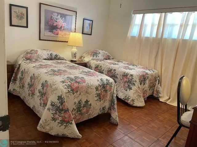 a spacious bedroom with two beds and painting on the wall