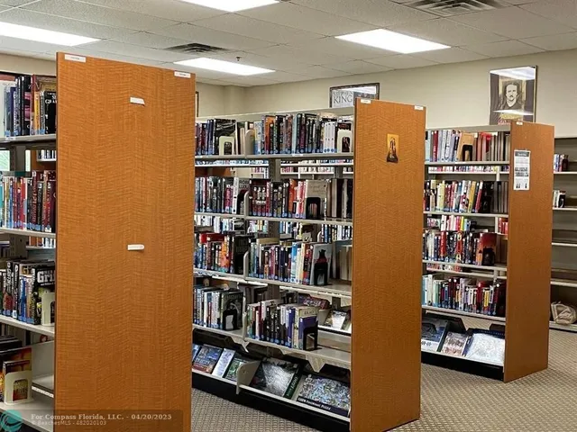 a view of a workspace with furniture and book shelf