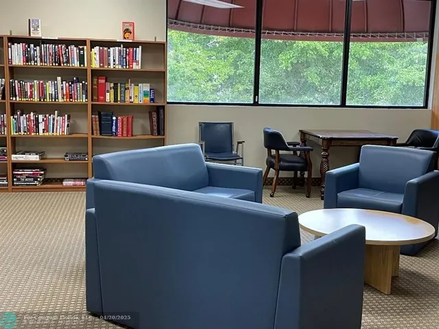 a living room with furniture and a book shelf