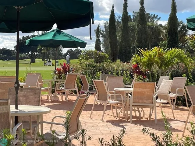 a view of a patio with furniture and table under an umbrella
