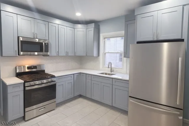 a kitchen with stainless steel appliances a refrigerator stove and microwave