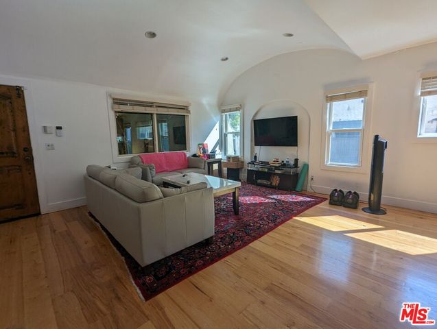 a living room with furniture wooden floor and a flat screen tv