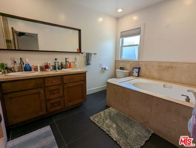 a bathroom with a tub sink and mirror