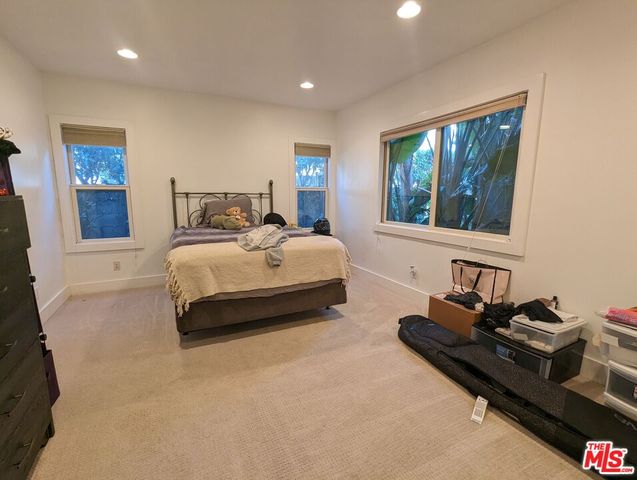 a bedroom with a bed and dresser with mirror