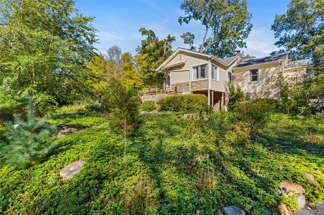 a view of a house with backyard and a tree