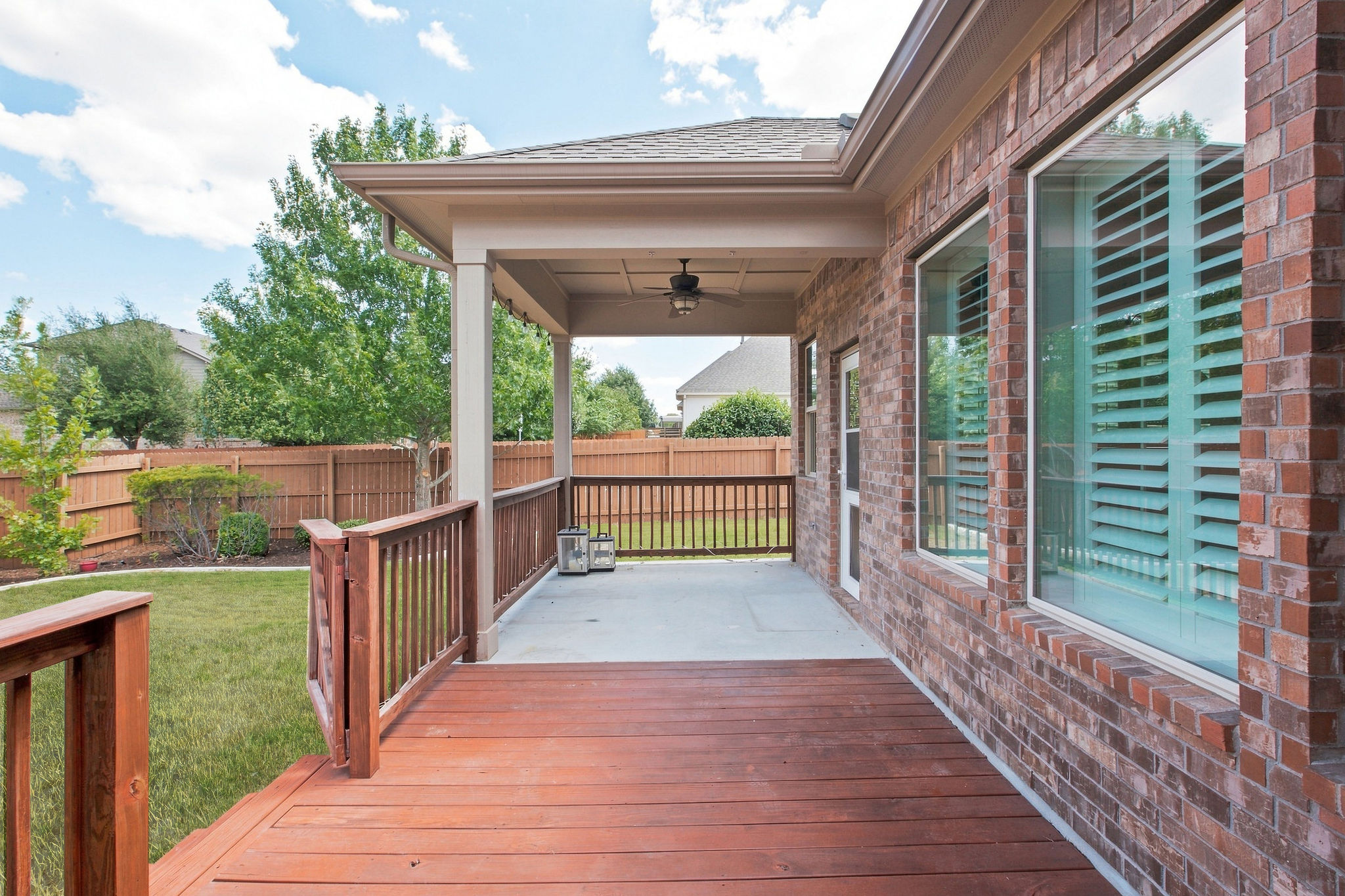 6100 Gunnison Turn Road Austin, TX 78738 - Photo 29 of 34 An inviting covered patio and wooden deck extend alongside the classic brick exterior.