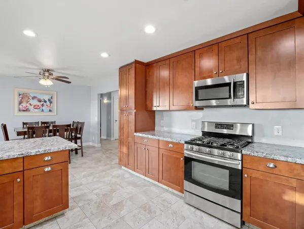 a kitchen with granite countertop wooden cabinets stainless steel appliances and a counter space