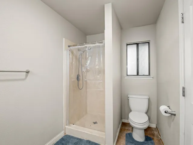 a bathroom with a granite countertop toilet a sink and shower