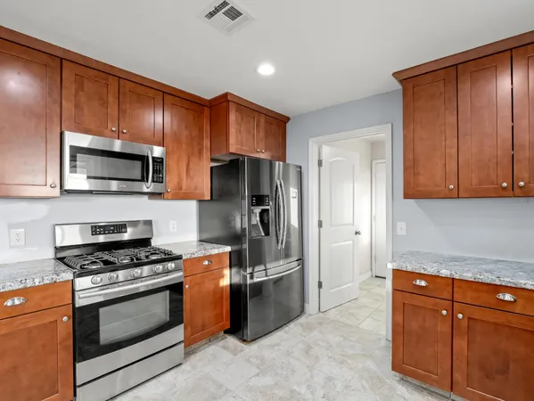 a kitchen with stainless steel appliances granite countertop a refrigerator stove and microwave
