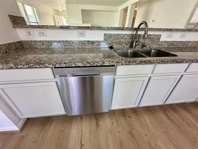 a kitchen with granite countertop a sink and a stove