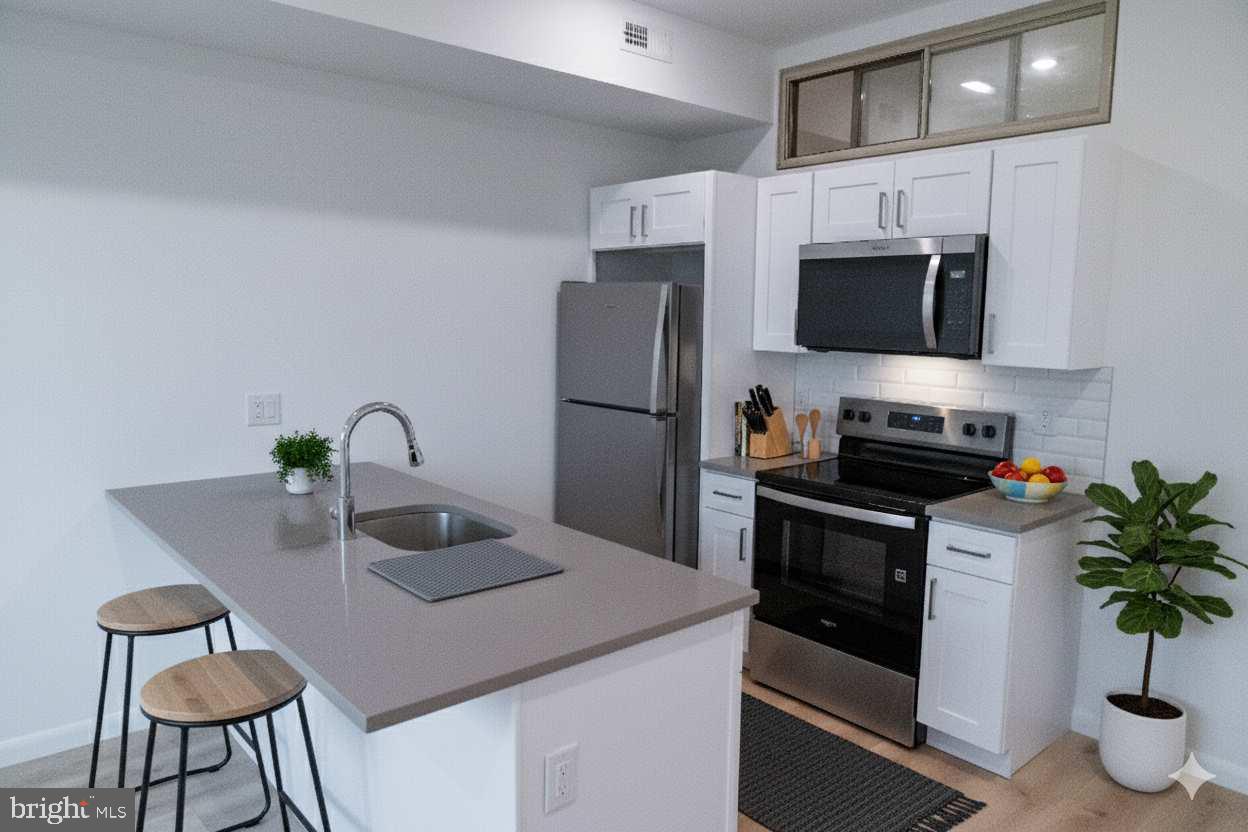 a kitchen with stainless steel appliances a stove a sink and a microwave