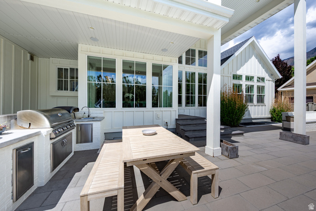 630 East Center Street Alpine, UT 84004 - Photo 102 of 115 Expansive outdoor patio featuring an integrated outdoor kitchen with a stainless steel grill and sink, a covered dining area, and large format paver flooring